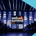 Plateia de executivos e diretores no Web Summit Rio, o maior evento de tecnologia e networking da América Latina, com o palco principal ao fundo.